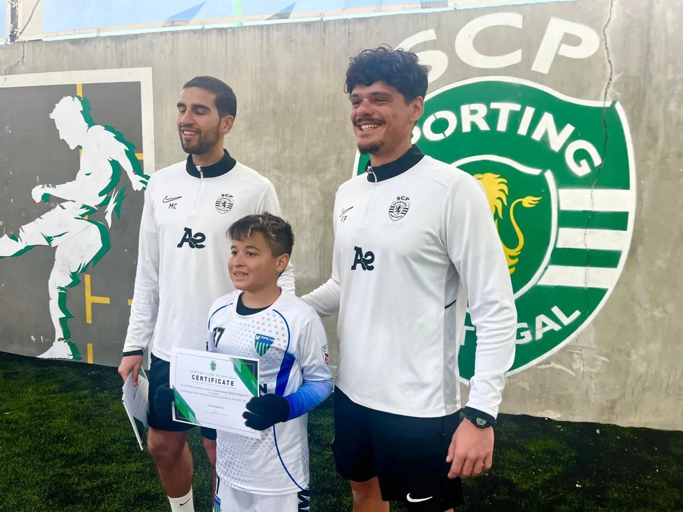 Jugador recibiendo su certificado con técnicos del Sporting de Portugal